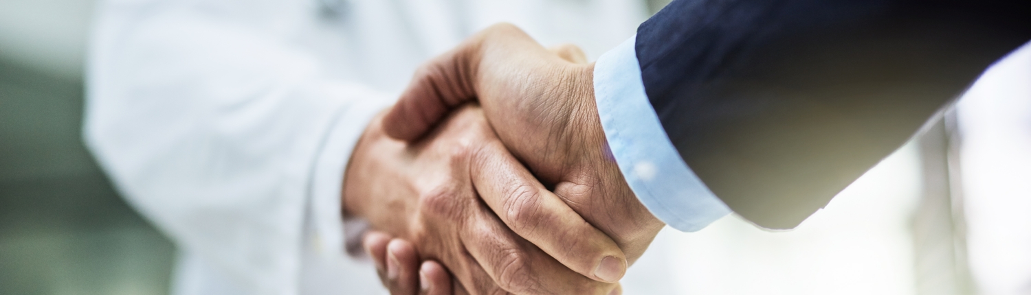 doctor and patient shaking hands in hospital