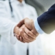 doctor and patient shaking hands in hospital